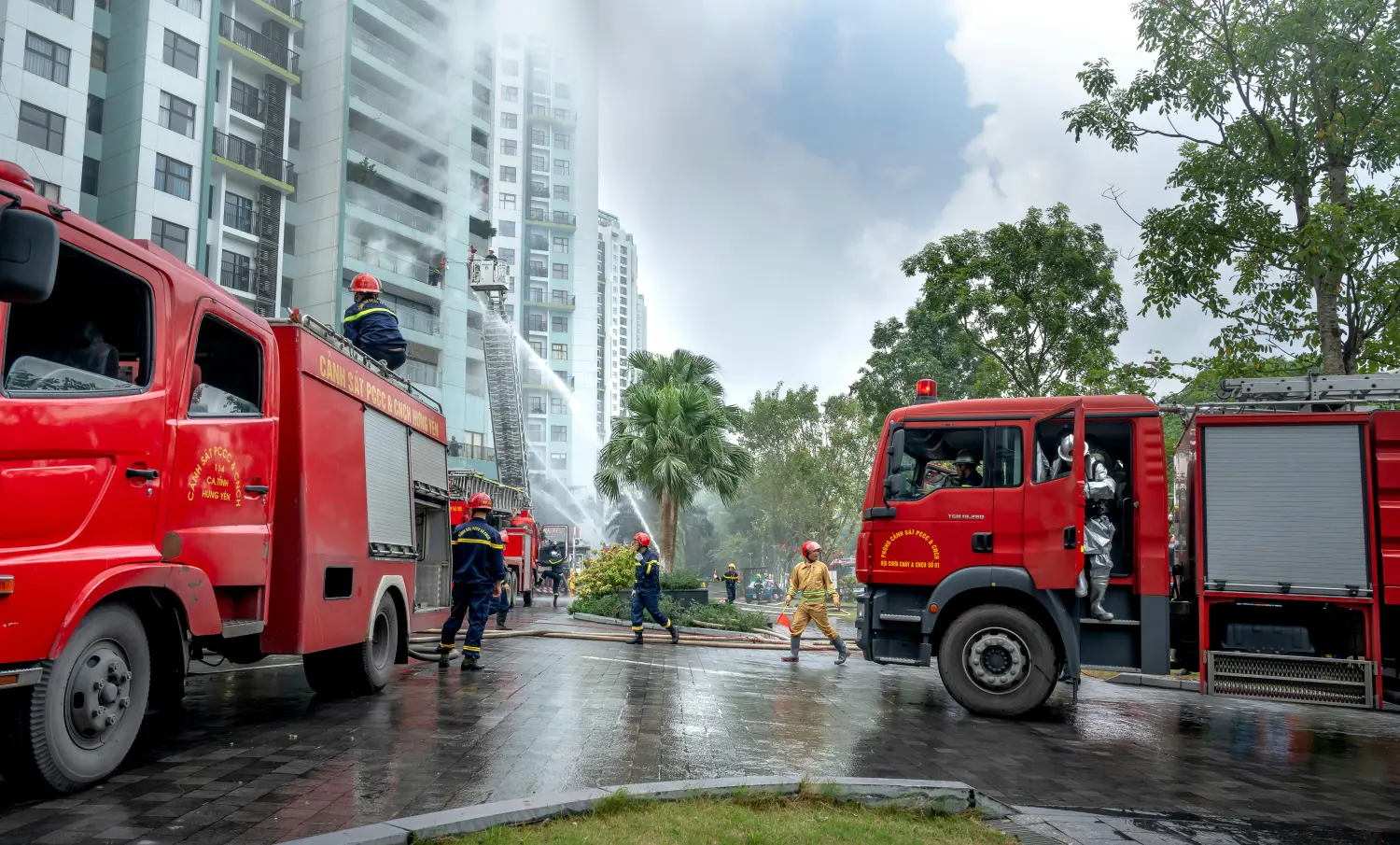 Feuerwehrleute zu Fuß, Löschfahrzeug im Hintergrund